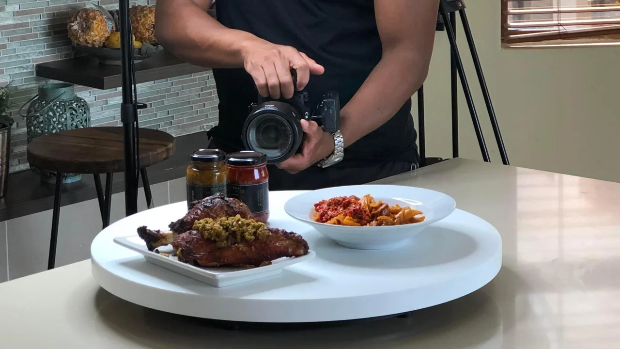 Camera operator composing a close-up shot of a plated dish