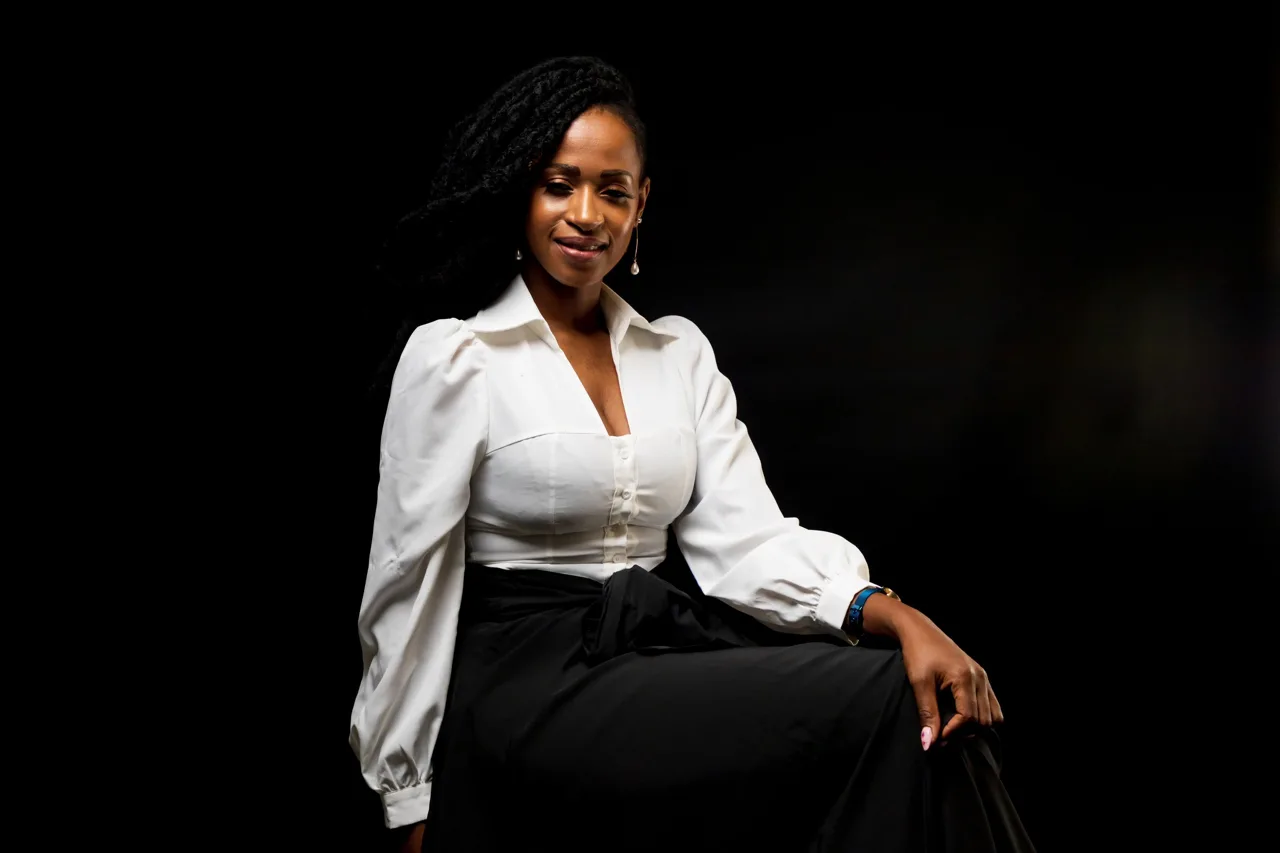 Studio portrait of a woman seated against a dark background